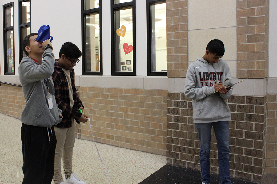 Sophomore Leo Larsen, sophomore Nathan Chandran, and freshman Sanjheev Rao take measurements as part of an activity in geometry classes this week. 
