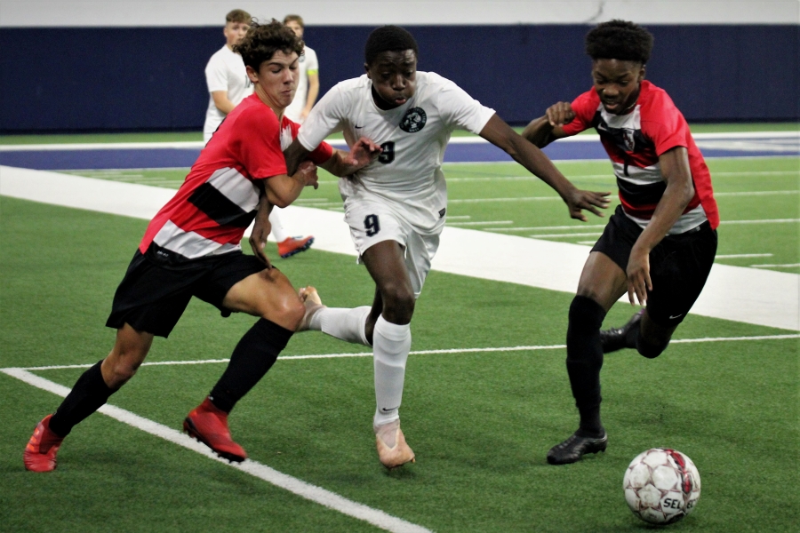 Sophomore Ashton Schramek and Cameron Wooley chase the ball as number Sammy Scott (#9) from Reedy High School tries to break through their defense. The boys team was able to hold off the Lions and get the 3-2 win at the Ford Center on Friday, Jan. 17, 2020.  