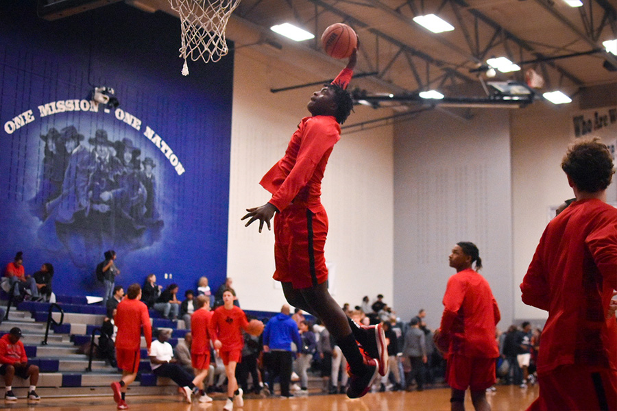 Prior to the game against Lone Star, senior Micaiah Abii attempts to dunk the ball.