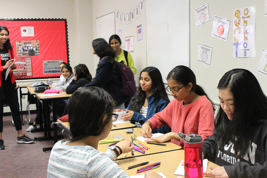 Female students converse while working on projects for the organization at Tuesday's Girl Up meeting.