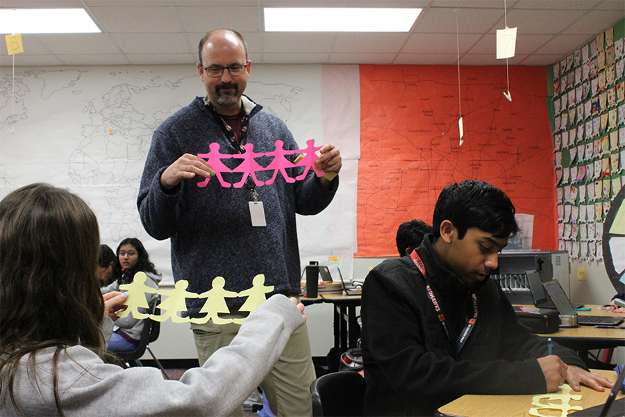 Freshman Hanna Knox compares her paper doll chain to the example being held by AP Human Geography teacher Tim Johannes on Thursday, Jan. 24, 2020. 

The project was part of a new unit look at agriculture around the world. For this specific assignment, students learned about how new technology can impact agriculture and the role of women in agriculture.  