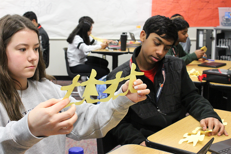 Holding up her paper doll chain Hanna Knox examines her work while fellow freshman Vishnu Vasudev takes a look at his creation.

The students made paper doll chains as part of a new unit in AP Human Geography with teacher Tim Johannes using the project to explain the role of women in agriculture. 