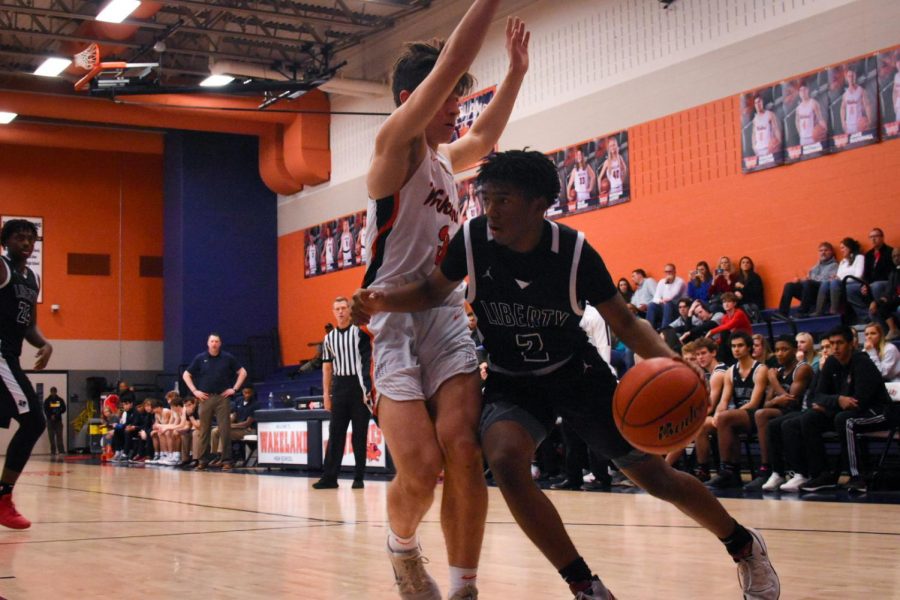 Trying to break through the Wolverine defense, junior Trey Walters dribbles the ball at Tuesdays game against Wakeland. The boys play their final home game at 7:15 p.m. at the Nest.