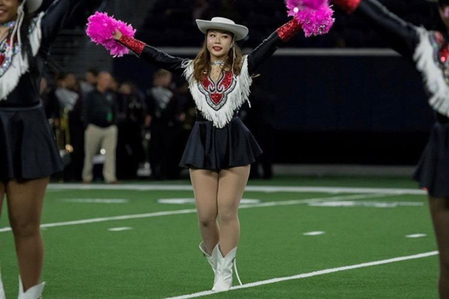 Walking across the football field, junior Amy Kim works through Red Rhythms pom pom routine. Though Kim auditioned for the team with little prior experience, Red Rhythm quickly became an important part of her life, and she became an important member of the team. 