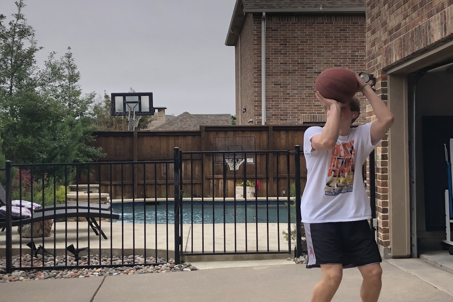 Senior Zach Bishop stays active by playing basketball outside. Although everyone is advised to remain indoors, students are trying to be healthy and active from the comfort of their own home.
