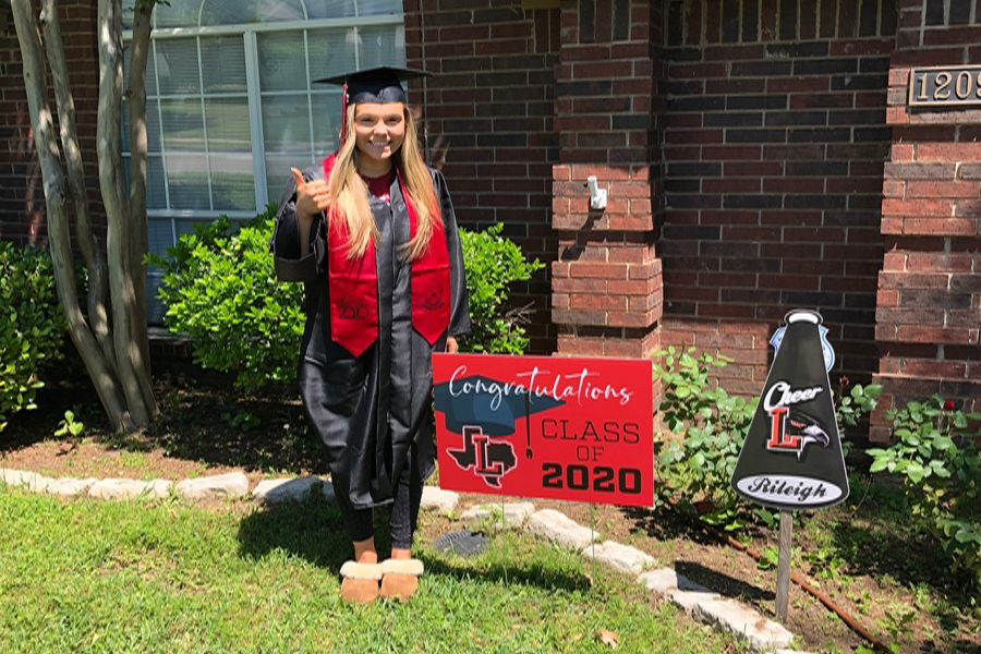 Senior Rileigh Horcher wears her cap and gown while posing next to a celebratory yard sign. The PTSA wanted to celebrate seniors in light of an in-person graduation being cancelled.