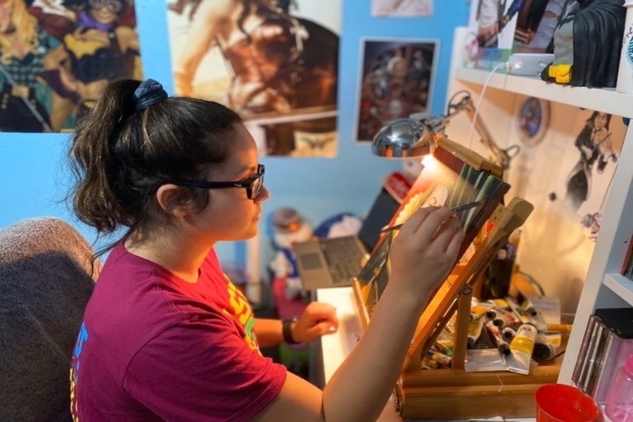 Junior Emma Valera works on a piece for her art portfolio. AP Art students bring the creativity to their bedrooms to finish up their portfolios for the year.