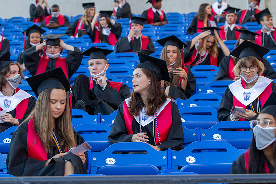 In their Jostens caps and gowns, the class of 2020 sits in the stands at their graduation ceremony last year. In almost a month, the Class of 2021 will join  them in becoming Redhawk alumni, with caps and gowns available for pickup Wednesday and graduation scheduled for May 23 at the Ford Center at The Star. 