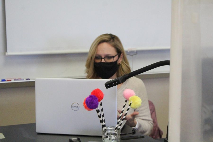 Mask on, AP Environmental Science teacher Jamie Berendt sits behind her desk during the school day. To escape life outside of school, Berendt takes part in scuba diving, having been a certified scuba diver since she was 16-years-old.