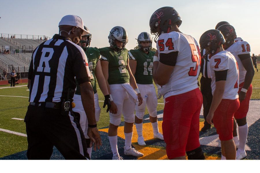 Captains for both the Redhawks and Reedy Lions stand at the 50-yard lion with the referee for the opening coin toss at Kuykendall Stadium on Aug. 26.