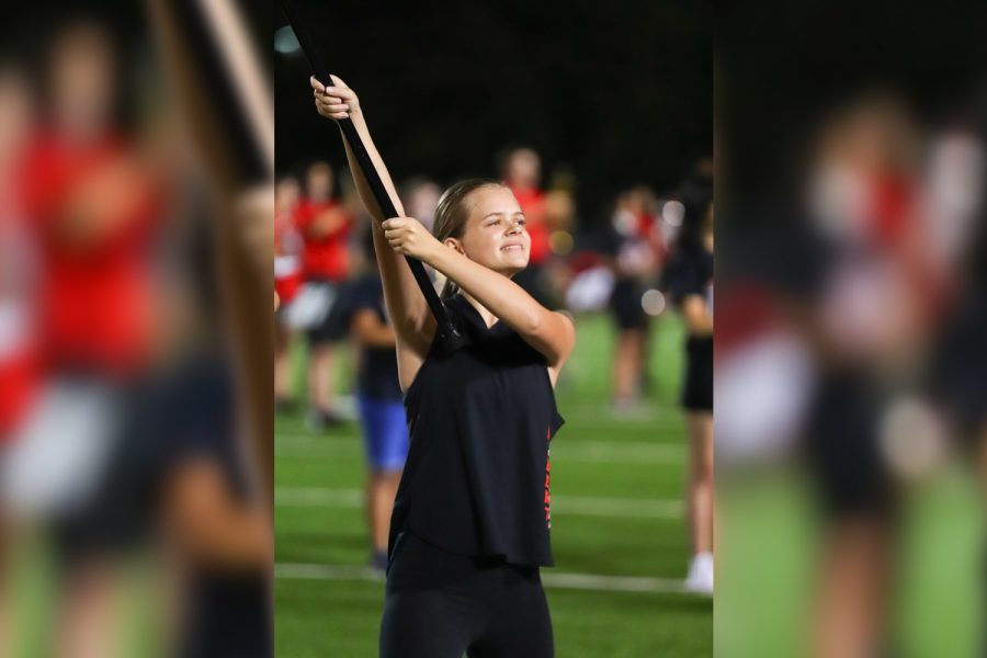 Performing at halftime of the Redhawks District 7-5A game on Sept. 9, Color Guards Ashton Hatch holds her flag on the field at Kuykendall Stadium. 