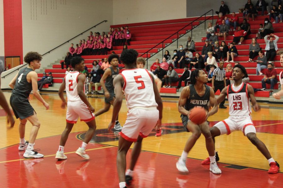 Attempting to defend the basket, the Redhawks are focused in on their defense. To stay ahead #23 Jacobe Coleman looks to block the shot.
