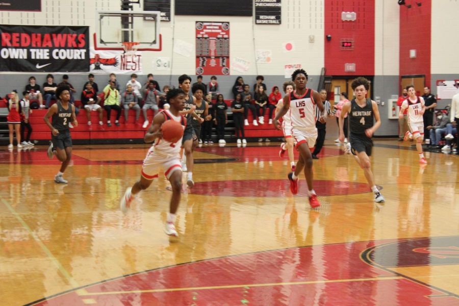 Streaking towards the basket, junior Trenton Walters (#2) looks to score an easy two with teammate Jonathan Dupree-Buford (#5) trails behind as Heritages Taven Washington (#4) tries to catch up on in the Redhawks 65-63 win on Tuesday in The Nest. 