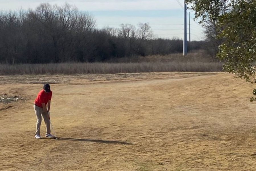 Sophomore Kaden Crocetti hits his recovery shot from just behind the 10th green.
