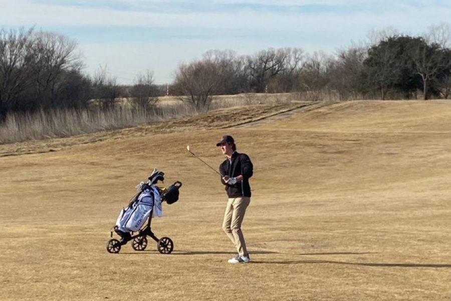 Senior Mitchell Kalka watching his short approach shot on the 10th hole.