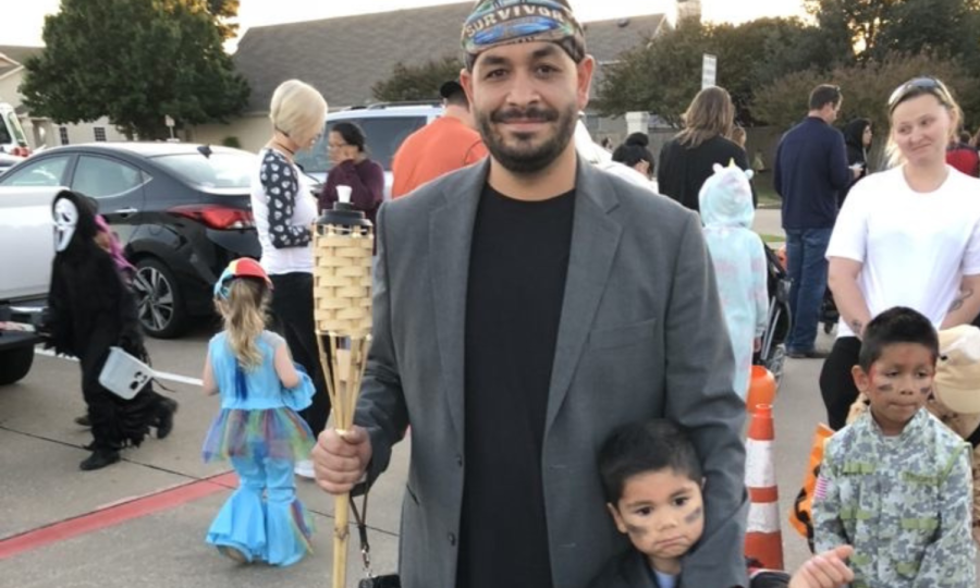 Pictured: Art teacher Fred Rodriguez poses for a picture with his son at Octobers Trunk or Treat event, where he dressed up as a contestant on the popular television show Survivor. Rodriguez now plans to make this dream a reality as he awaits the answer to his Survivor contestant application, which was sent in this spring. 