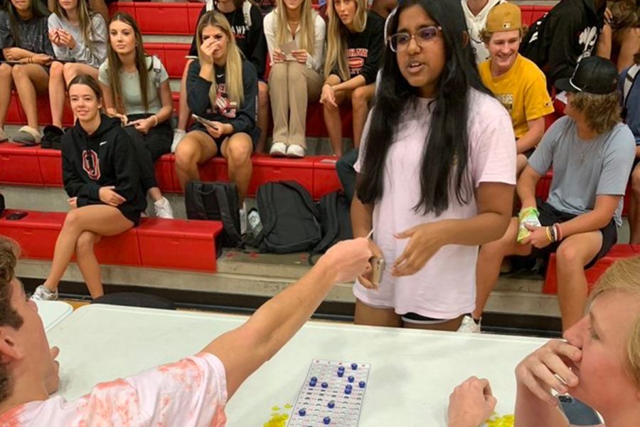 Hoping she hit a Bingo, freshman Lakshita Singh gets her card back from Student Council member Matthew Bishop as fellow  Student Council member Jake Harvey looks on. 