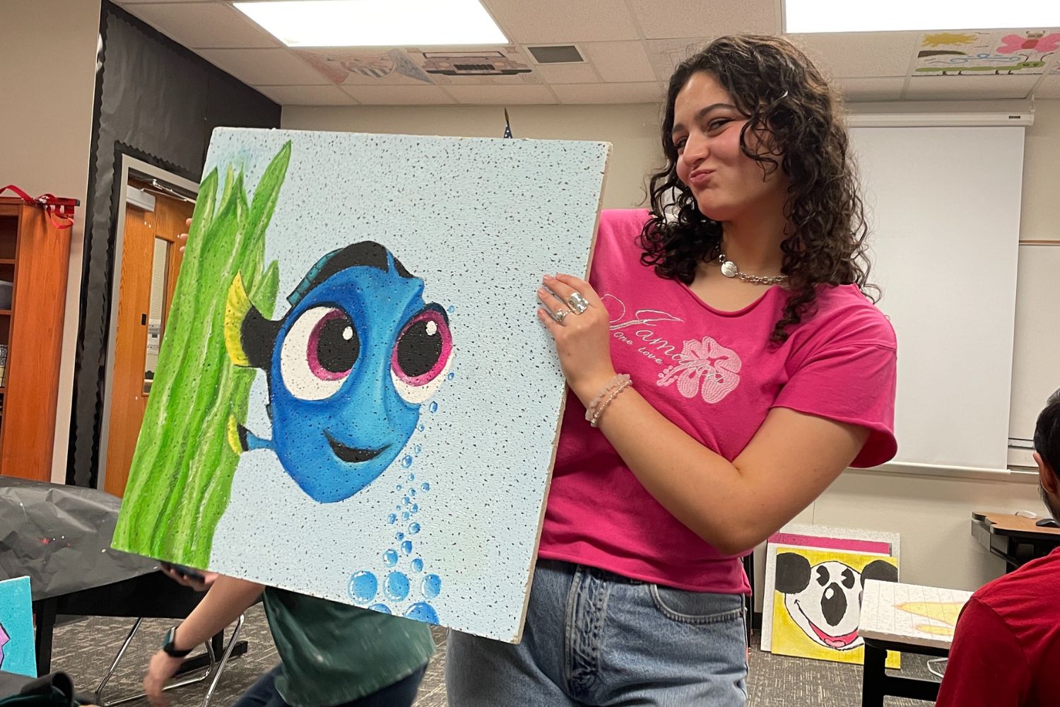 Senior Eva Soto (pictured) is one of many students who has painted and displayed a ceiling tile. “I loved walking around and seeing people’s ceiling tiles every year,” senior Eva Soto said. “When we did ours, we wanted it to be one that people really liked and thought was good, so we put a lot of effort into it to make it a good grade but also looking really appealing.”