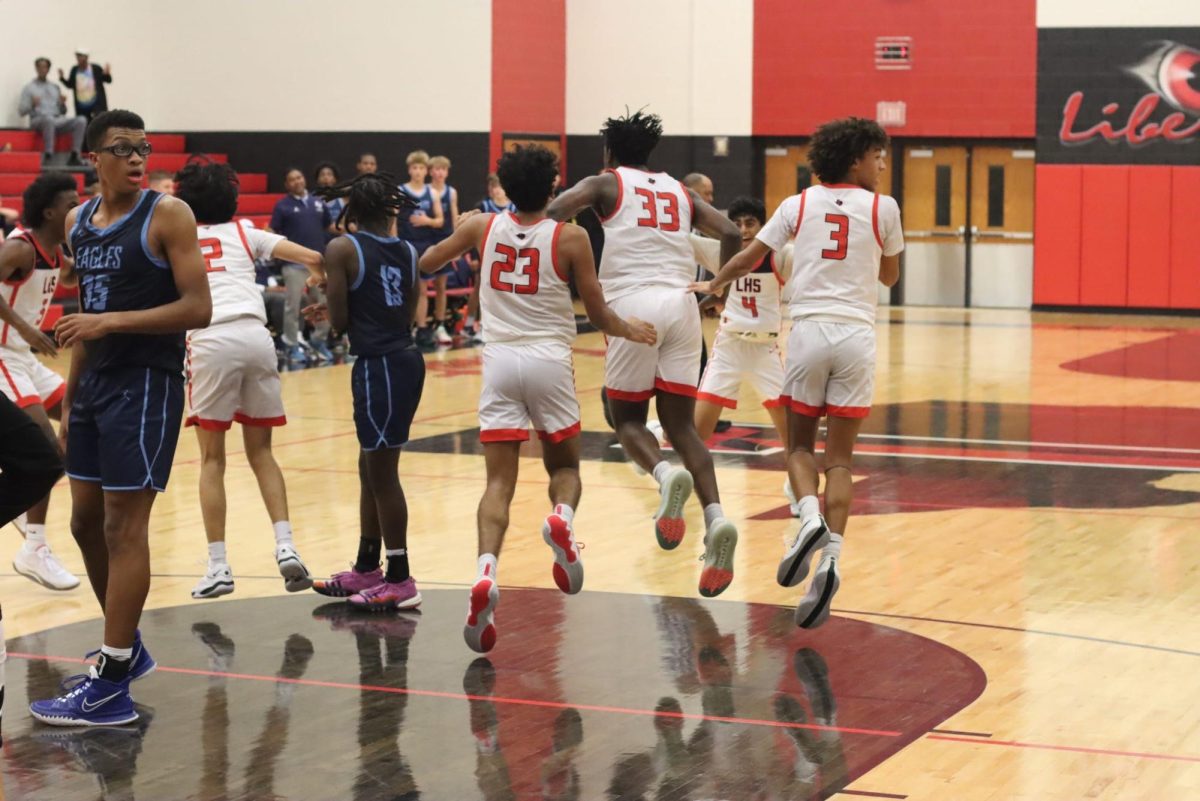 Pictured are number 33, 23, and 3, Gilbert Aluga, Eshan Kumar, and Ian Williams. This is the moment Aluga scored a last second point, making the Redhawks victorious. 
