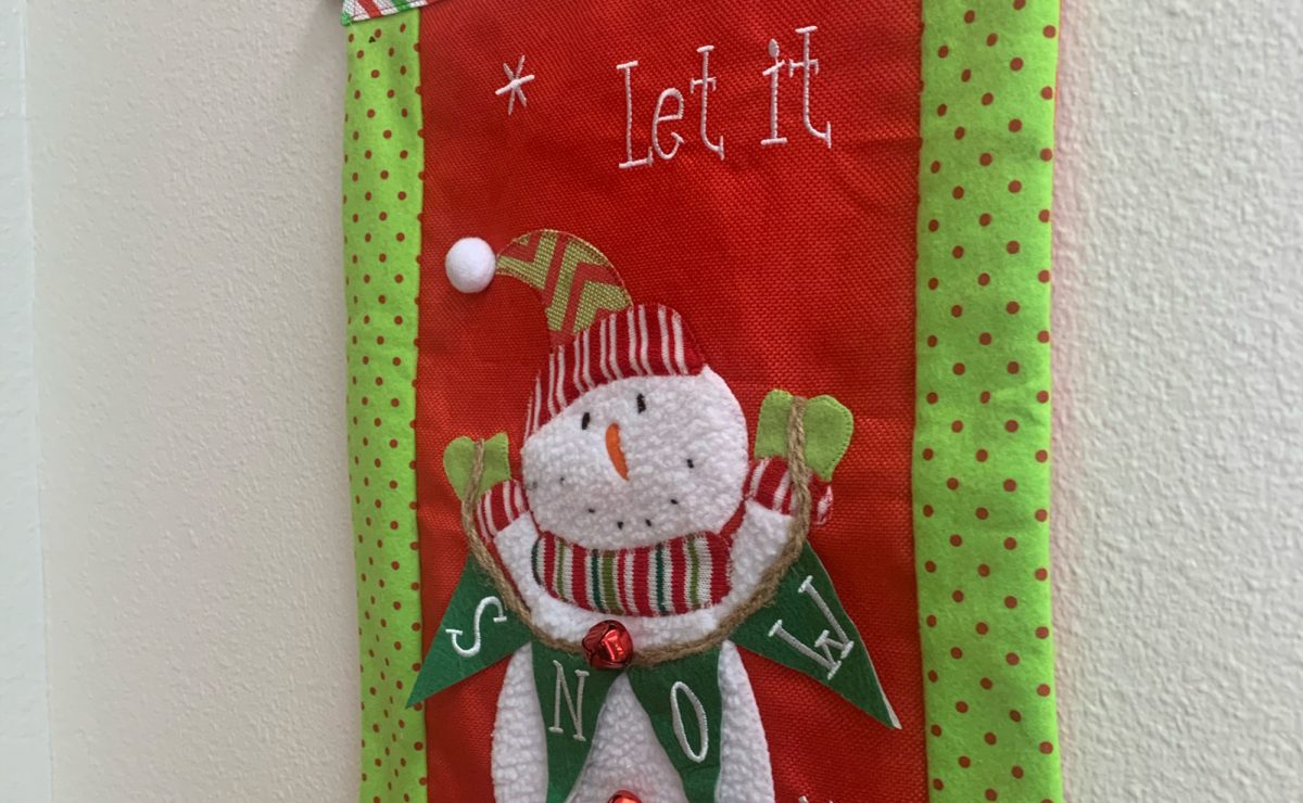 Holiday decorations can be seen throughout campus, including this Let it Snow flag hanging outside the room of Spanish teacher Ashli Taquinos room. 