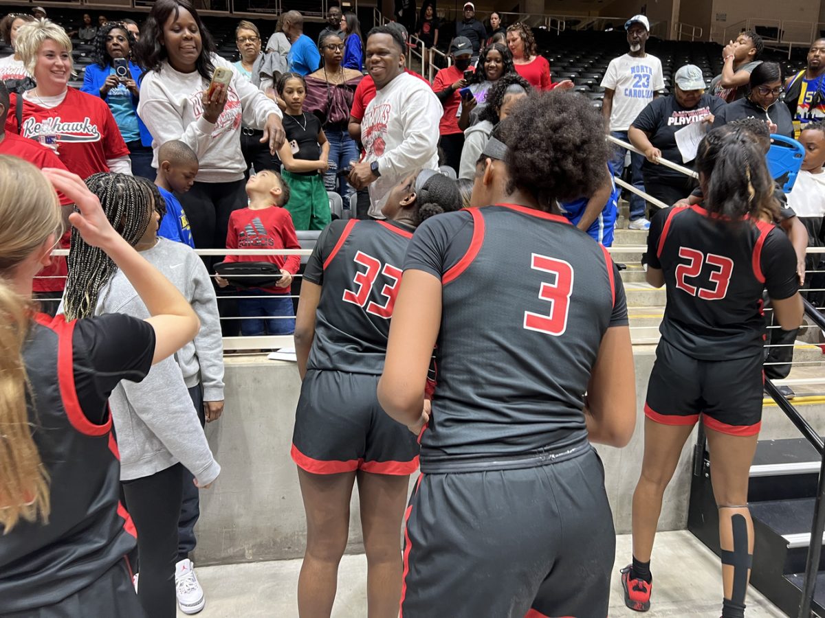 Finding their friends and family in the stands at the Curtis Culwell Center in Garland, the girls basketball team celebrates its 53-26 win over Princeton in the 5A Region II final that sent the Redhawks to the state tournament in San Antonio Thursday. 