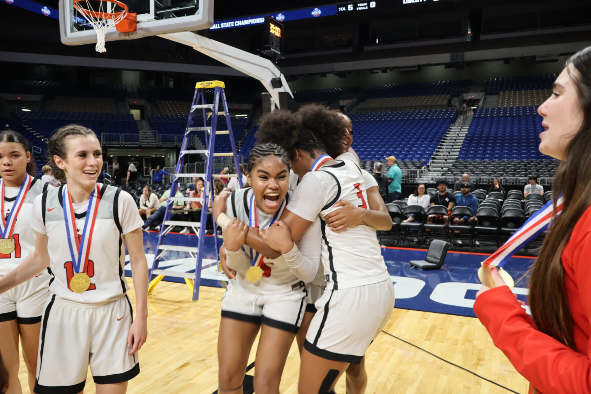 With sophomore Lilian Johnson and junior Kathryn Murphy looking on, junior Aziyah Frarrier, and sophomore Jacy Abii embrace senior Keyera Roseby after the Redhawks 60-51 win in Saturdays UIL 5A state championship against Mansfield Timberview. 
