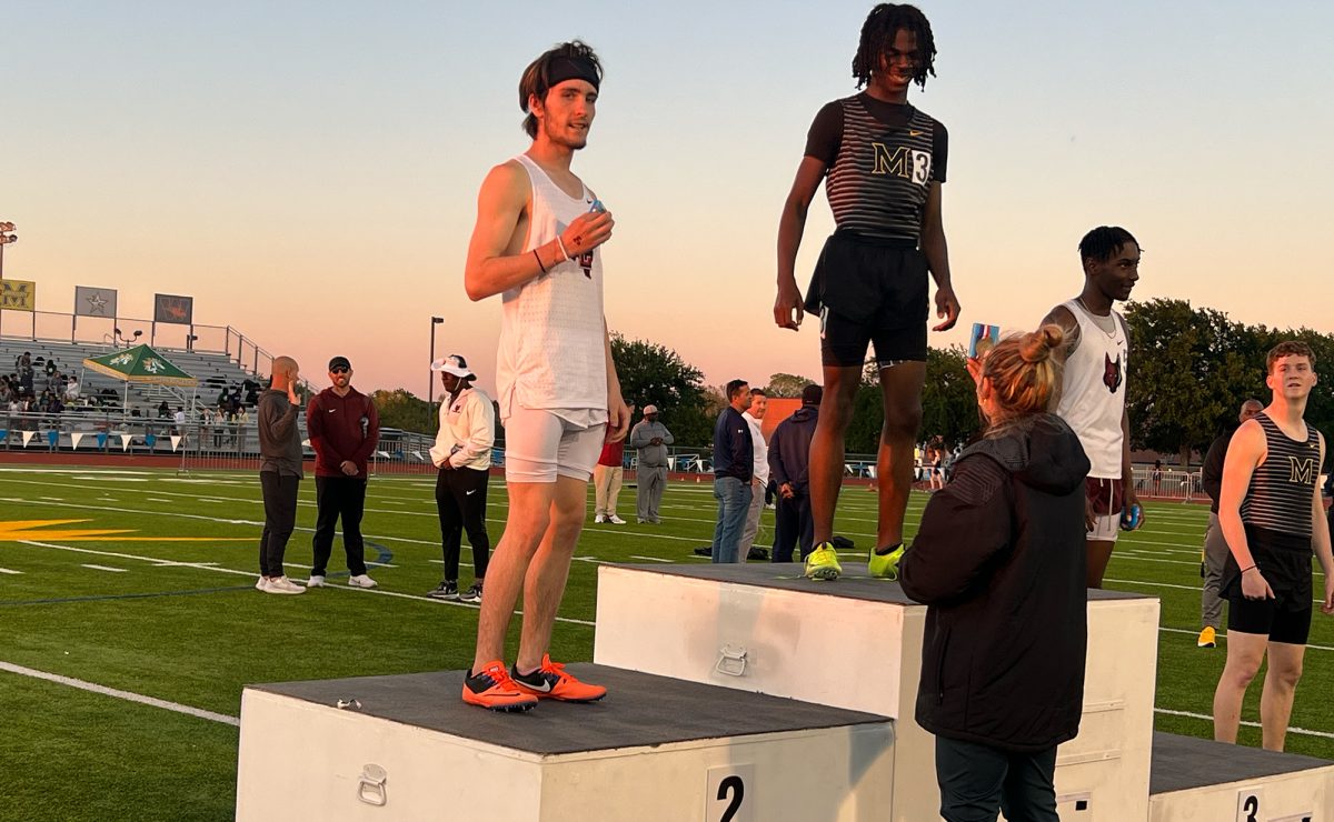 Brayden King steps onto the podium to receive his medal after a 2nd place finish in the 300 meter hurdles.