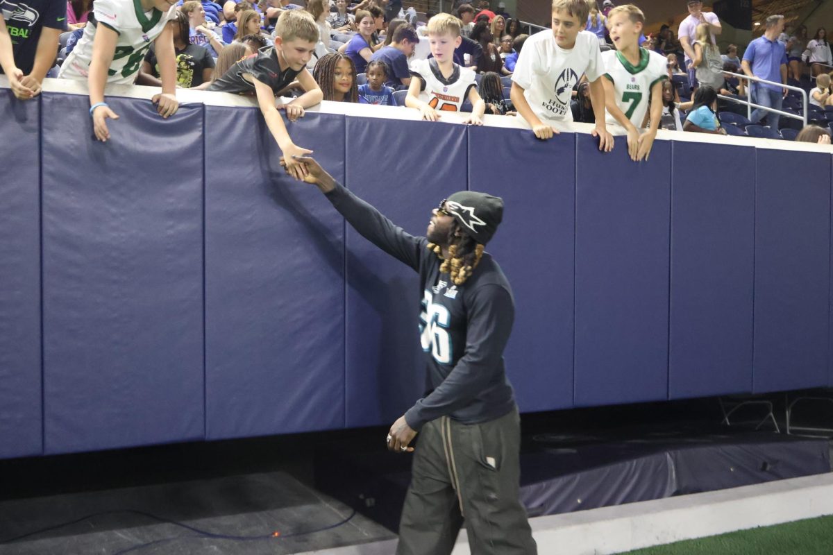 One of just three Frisco ISD football players to win a Super Bowl, former Redhawks star Jay Ajayi shakes the hands of fans at the Ford Center after being introduced as a member of the Class of 2025 FISD Hall of Honor.