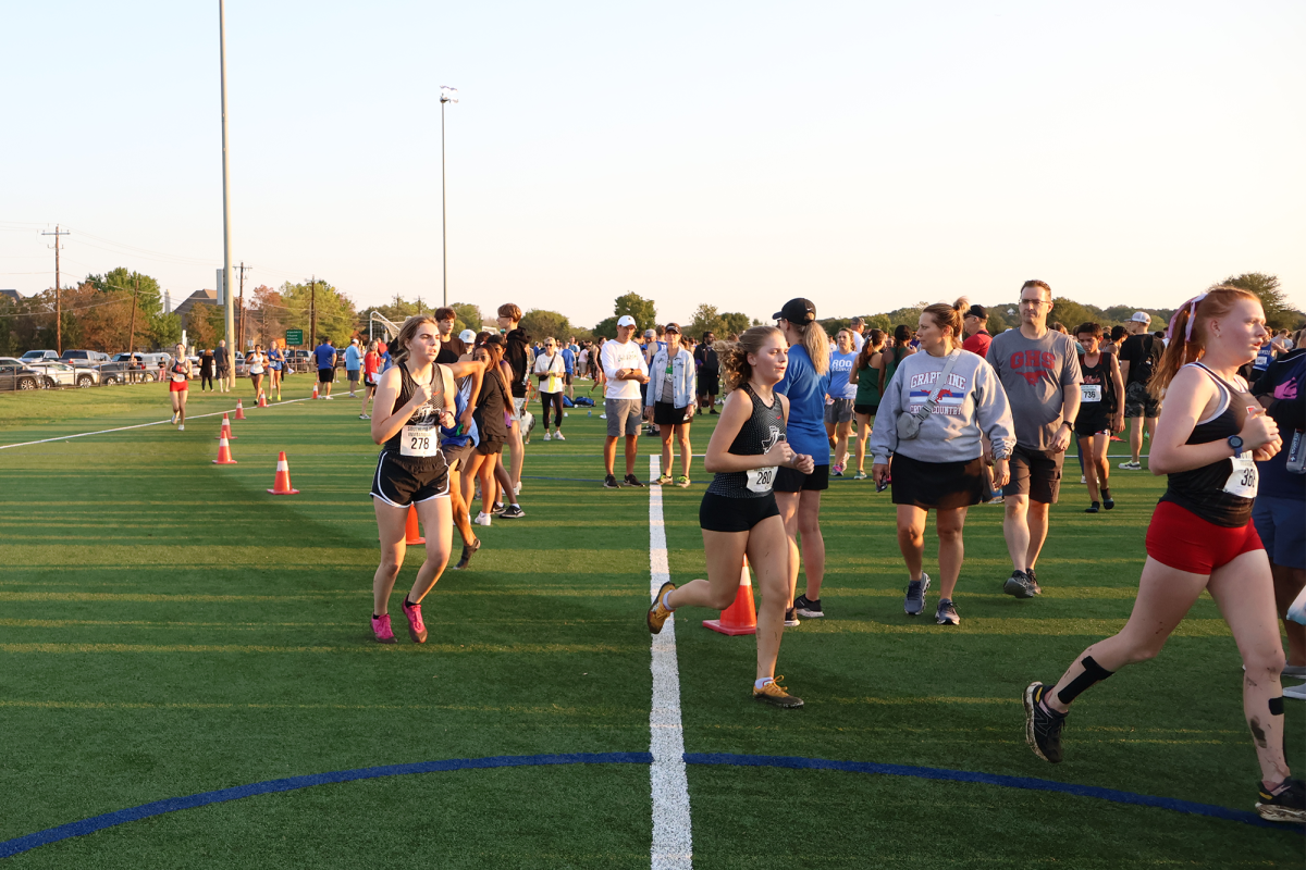 Seniors Meghan DeShetler and Addy Conrady run in the Southlake Invitational on Saturday despite the team's bus breaking down on the way to the meet. The Redhawks were able to make it to their meet on time with the help of parents.