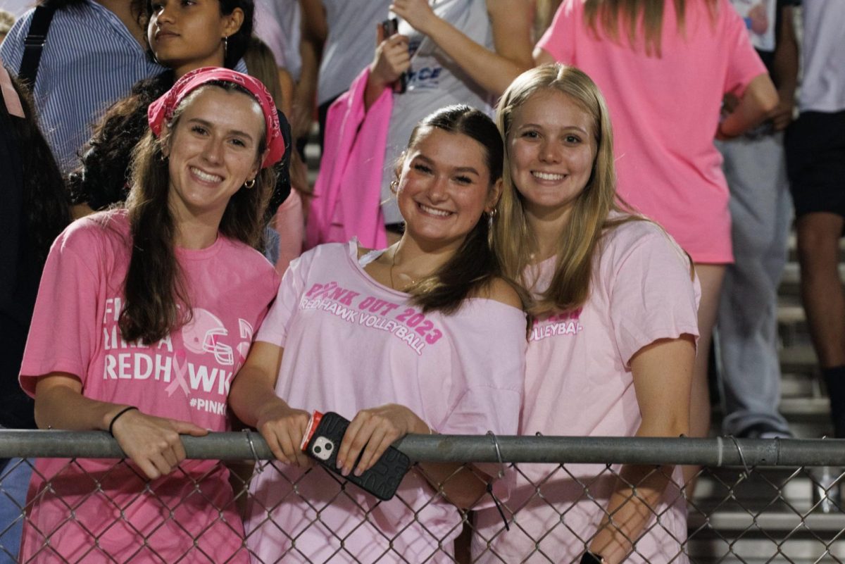 Seniors Kathryn Murphy, Sophie Paulk, and Brooklyn Brown go all out for pink out sporting shirts, bandanas, and bracelets. 