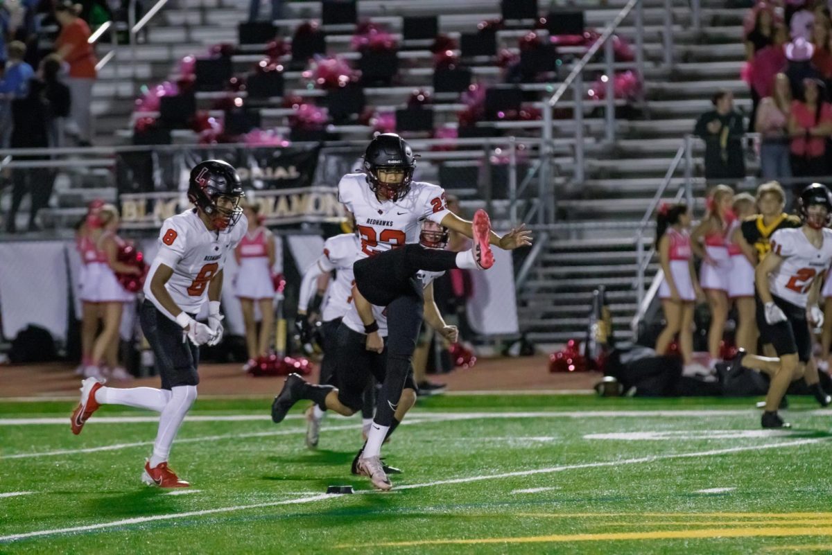 Joey Mediaceja kicks his cleats into the air for a field goal after the Redhawks score a touchdown. 