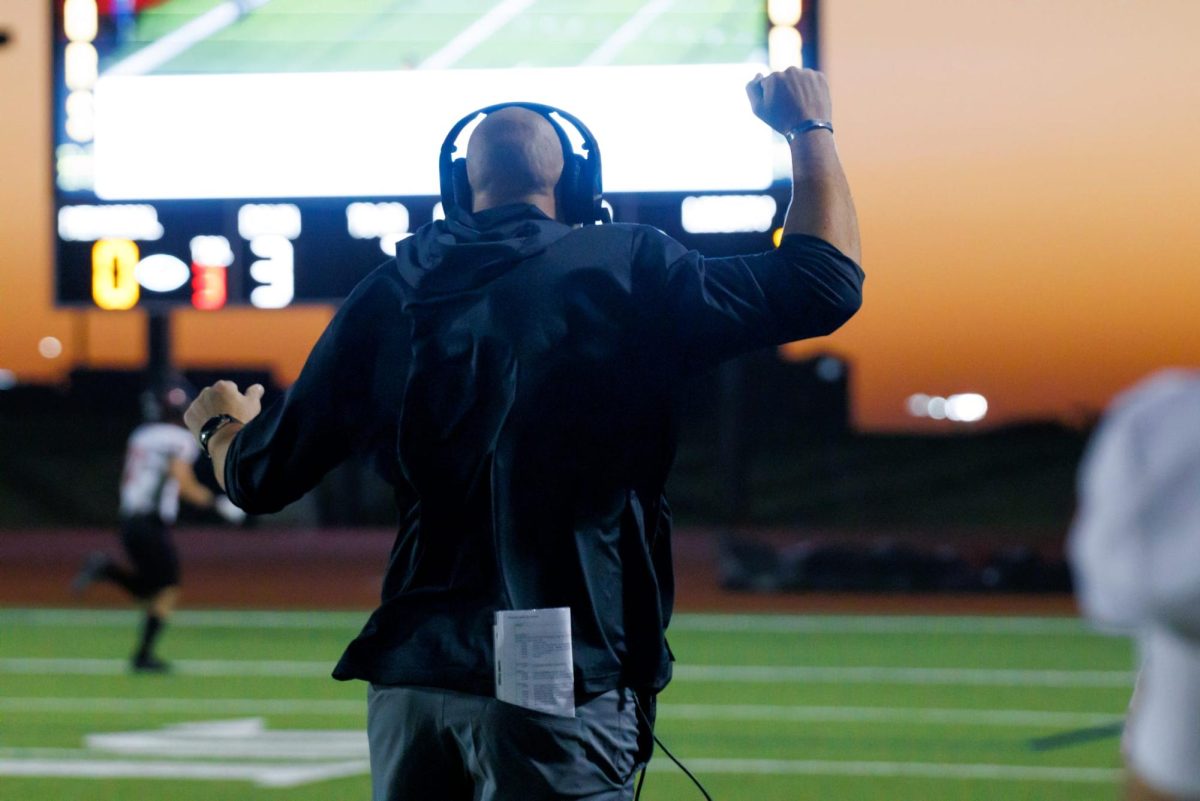 Defensive Coordinator Joshua Rebmann pumps his fist in the air as the Redhawks doar into the endzone. 