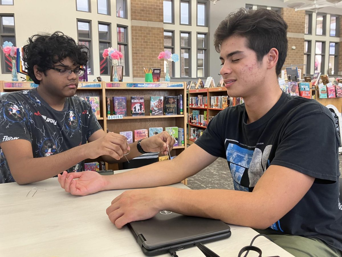 Junior Sirish Shabash tests junior Todd Stile’s perception of different twisted paperclips on various places of the arm and hand.