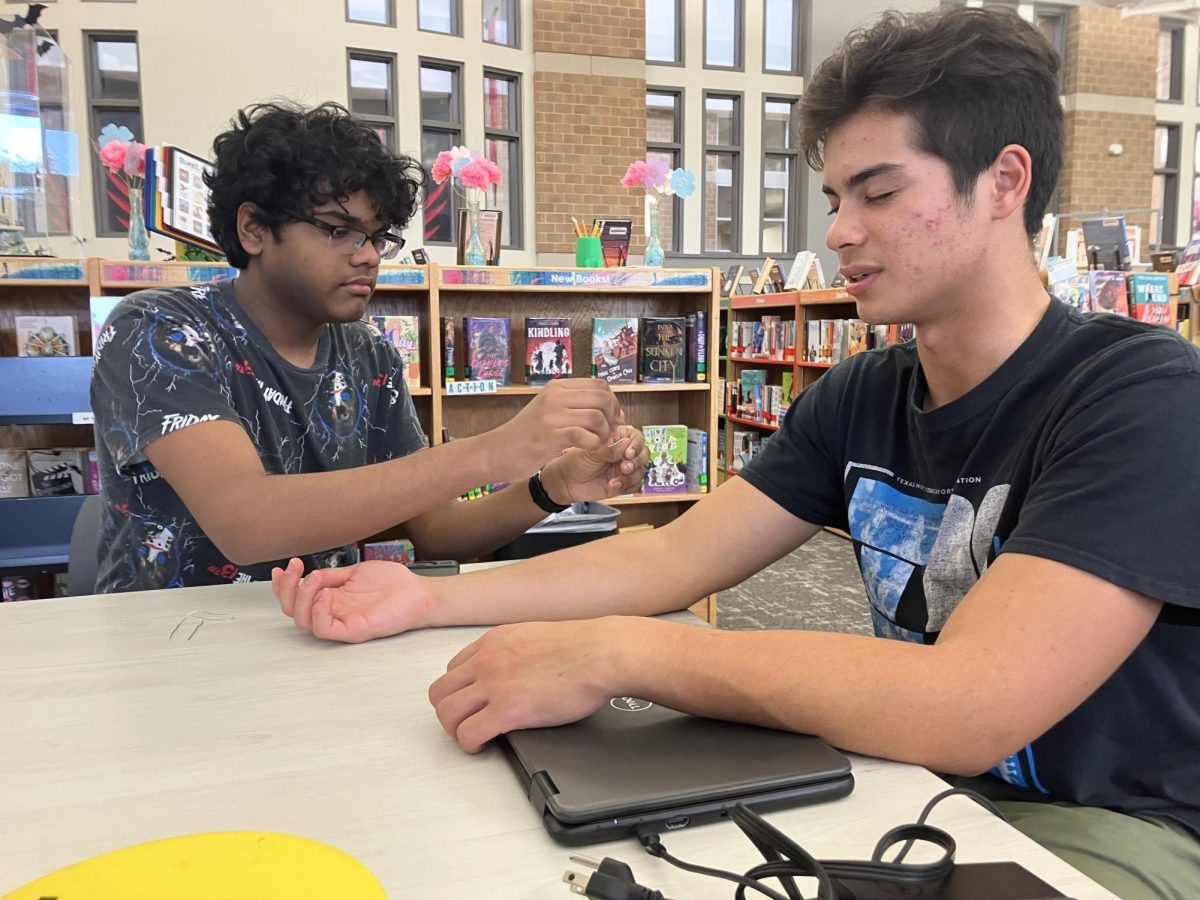 Junior Sirish Shabash tests junior Todd Stile’s perception of different twisted paperclips on various places of the arm and hand.

