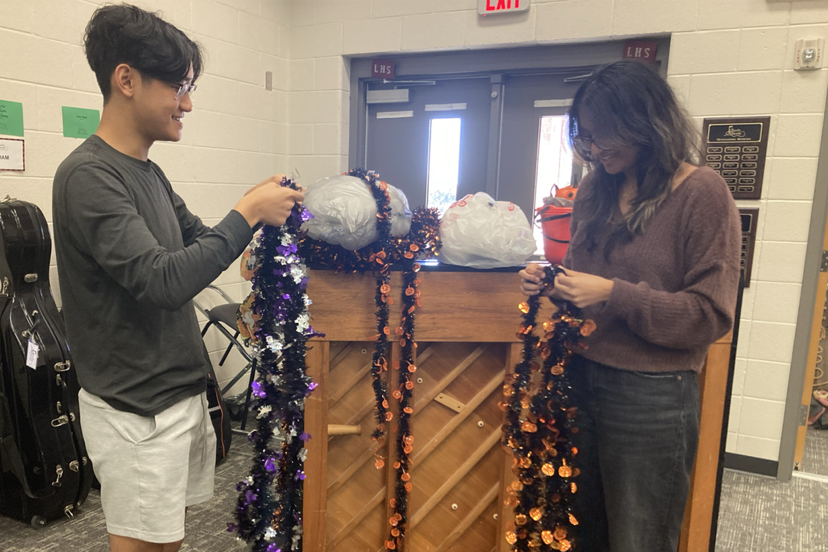 Seniors Nolan Sow and Avishi Singh untangle decorations, officially bringing the Halloween spirit to the orchestra room.