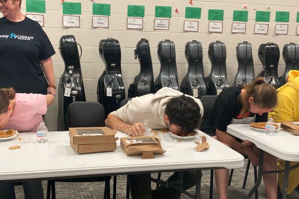 Orchestra students competed in various activities as a part of their Falloween celebration which included aspects of both Halloween and traditional Fall activities. Here, a student can be observed dipping their face in a pumpkin pie eating contest without their hands. 