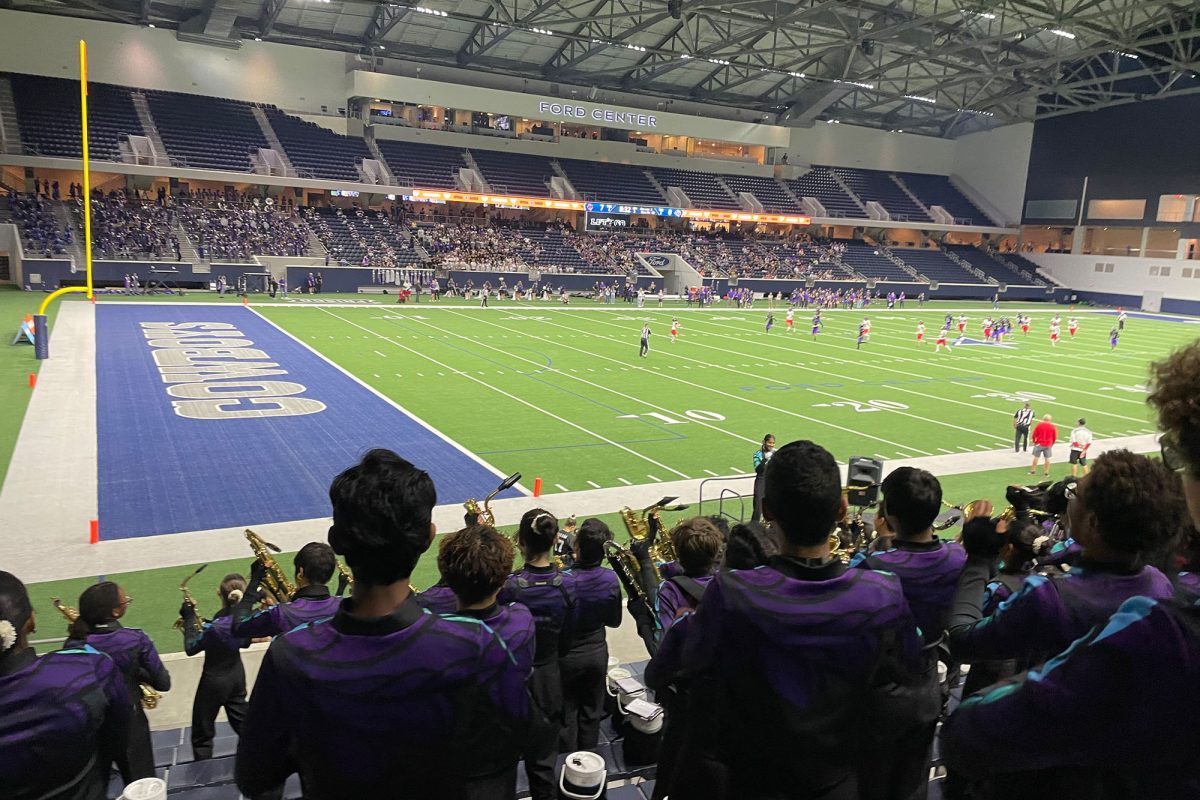 The pressure is on for the Redhawks as the football team race against the clock for another touchdown to offset the opposing team. The band passionately cheers them on as they swing their instruments from side to side. 