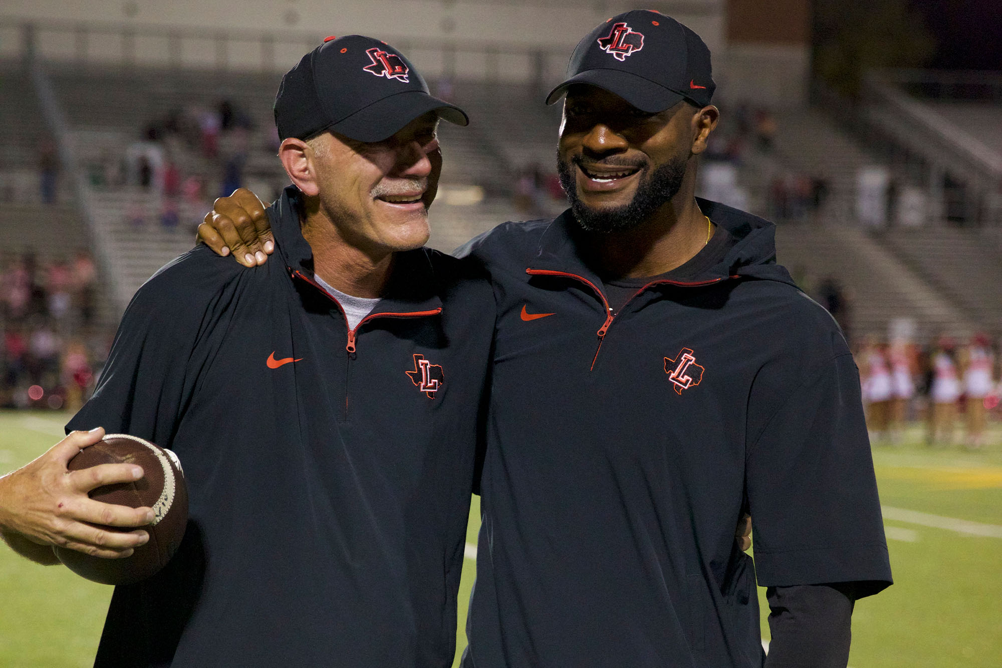 Matt Swinnea and Chip Gregory embrace as the team celebrates their first win of the season on Oct. 24, beating Memorial 28-7.