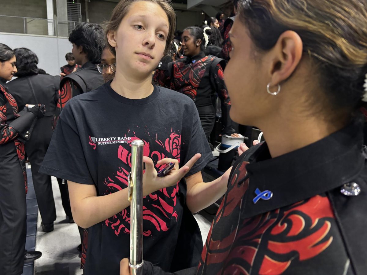 Freshman Dhitika Dubey introduces incoming freshman Madeline Cowley to marching band.