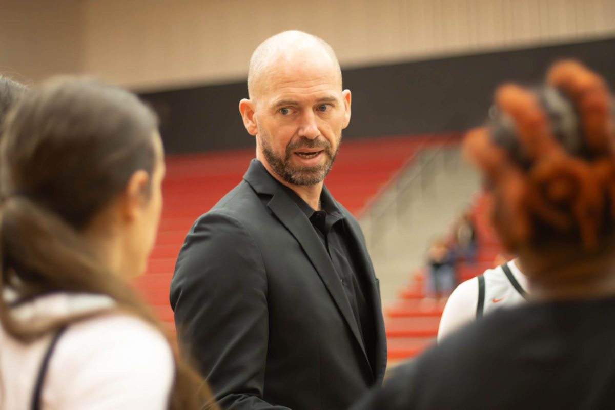 Girls' Basketball Coach Ross Reedy gives the pre-game talk in a team huddle.