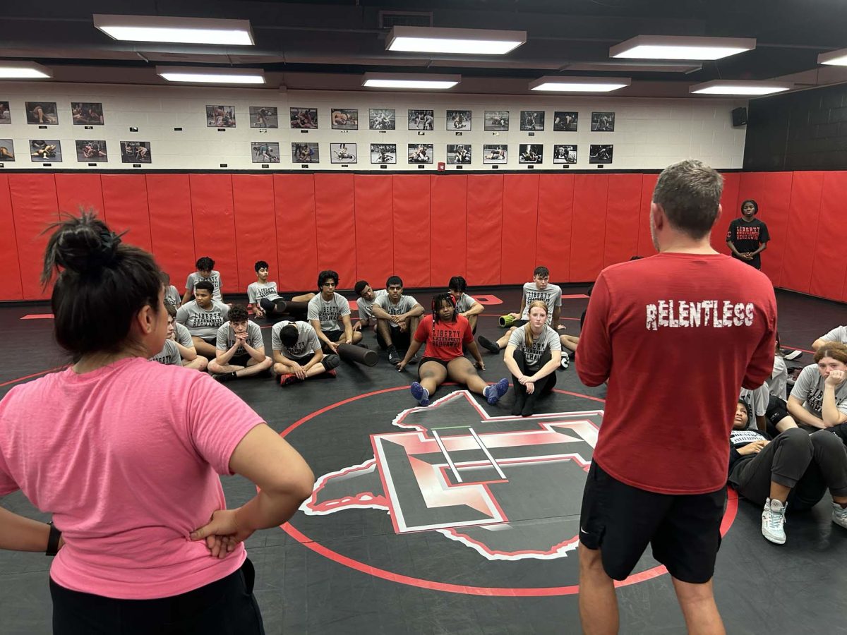 Wrestling coaches Viviana Espinoza and Justin Koons address the team at a recent practice. The girls' team is in Lewisville Friday and Saturday for the Texas Women's Classic. 