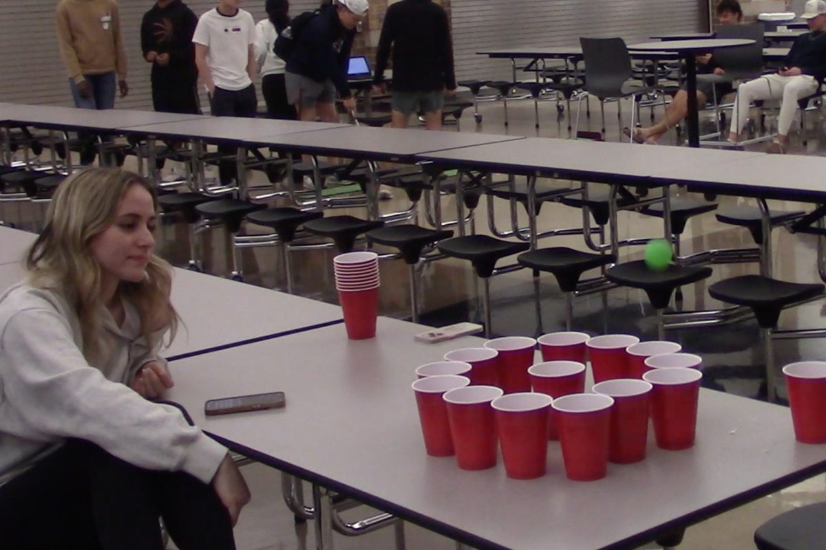 Senior Bea Dunlop watches and records data as students play her game. 