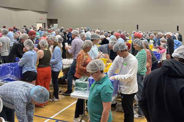 Members of Cottonwood Creek Church pack meals for communities in Kenya. Students earn hours for their efforts contributing to their 100 needed for a graduation cord.